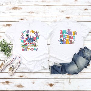 Puede incluir: Dos camisetas blancas con un personaje de dibujos animados azul. Una camiseta dice "Es mi cumplea&ntilde;os" y la otra dice "En mi era de cumplea&ntilde;os".