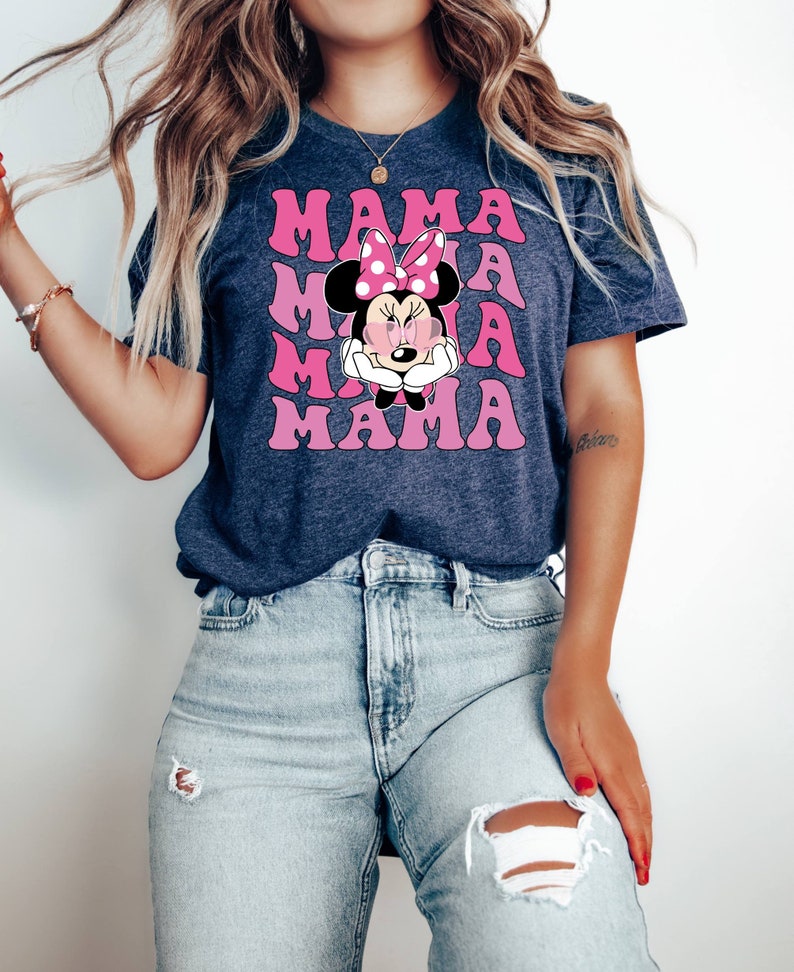 May include: A navy blue t-shirt with a pink and white graphic of Minnie Mouse with the word "MAMA" repeated in pink letters.