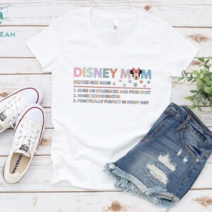 May include: White v-neck t-shirt with the text "DISNEY MOM (N)/DIZ-NEI MAM" and a cartoon image of Minnie Mouse. The text below the title reads "1. Runs on Starbucks and Pixie Dust 2. Magic Coordinator 3. Practically Perfect in Every Way"
