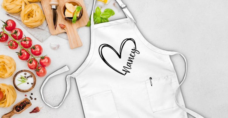 May include: White apron with a black heart and the name "Nancy" printed on it.