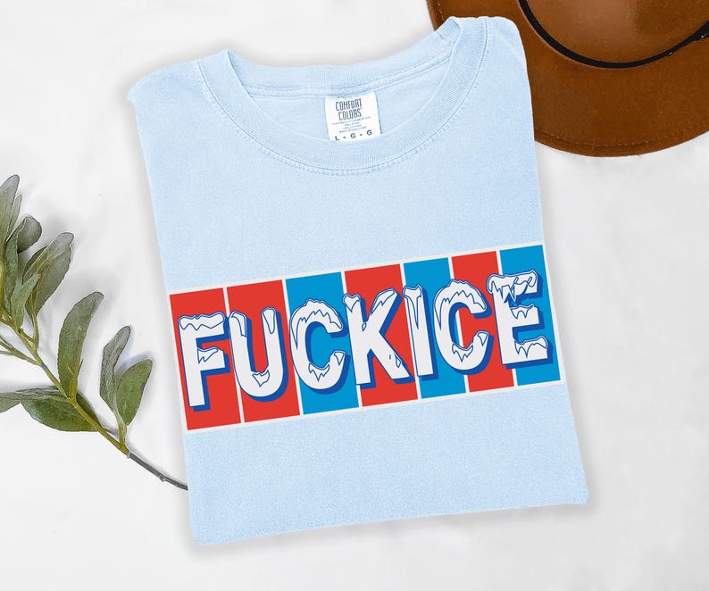以下が含まれることがあります： 赤と青のストライプの背景に、白の「FUCKICE」の文字が青で縁取られた、水色のTシャツ。柔らかい素材でできており、クルーネックです。