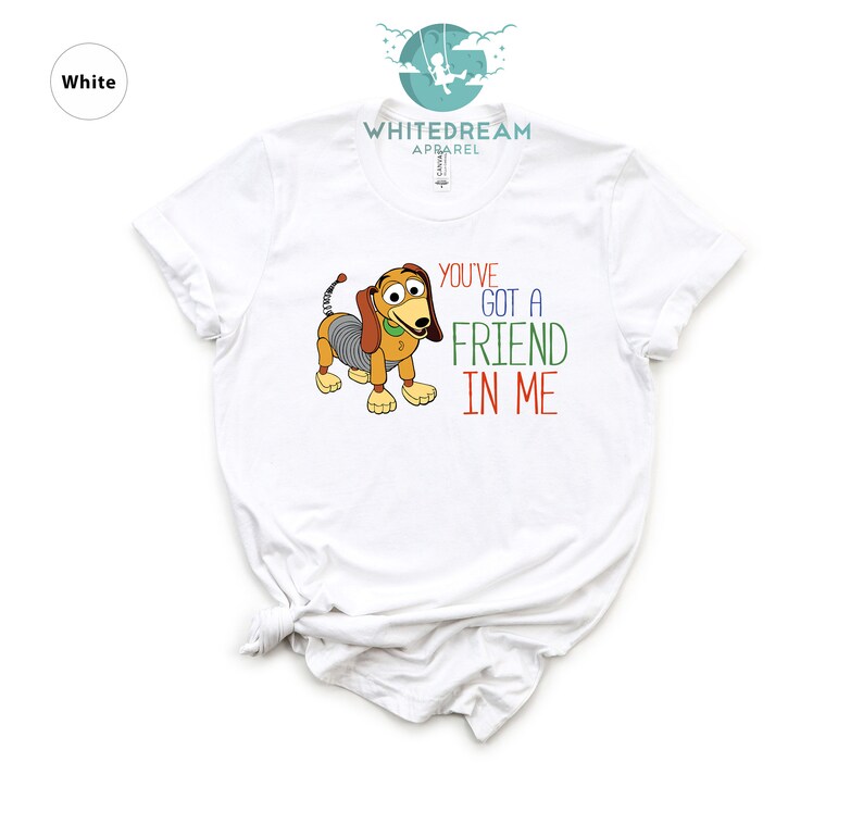 Op de afbeelding: Wit T-shirt met een cartoon afbeelding van een hond uit de Toy Story film. De tekst "You've got a friend in me" staat op het shirt gedrukt.