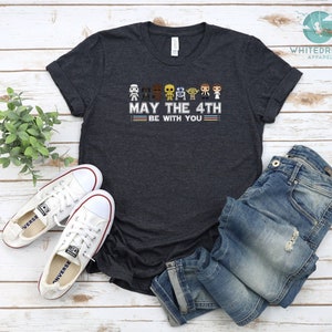 Op de afbeelding: Donkergrijs T-shirt met een afbeelding van Star Wars-personages en de tekst "Moge de 4e met je zijn".
