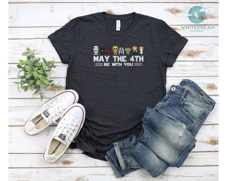 Op de afbeelding: Donkergrijs T-shirt met een afbeelding van Star Wars-personages en de tekst "Moge de 4e met je zijn".