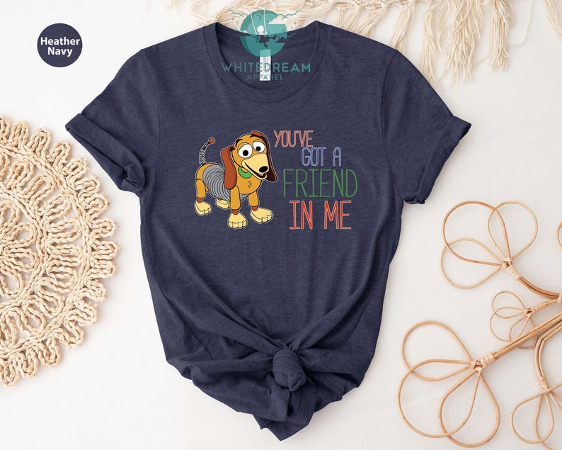 Op de afbeelding: Een marineblauw t-shirt met een cartoon afbeelding van een hond met de tekst "You've got a friend in me".