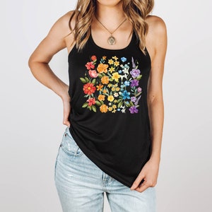 May include: A black tank top with a rainbow floral print. The flowers are arranged in a square shape and are in shades of red, orange, yellow, green, blue, and purple.