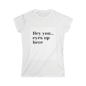 May include: White t-shirt with the text "Hey you... eyes up here" in black. The text is centered on the front of the shirt. The shirt has short sleeves and a crew neck.