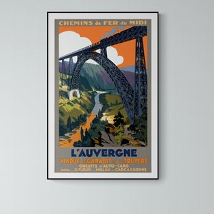 May include: A vintage travel poster for the Chemin de Fer du Midi railway line in France. The poster features a colorful illustration of the Garabit Viaduct, a steel arch bridge over the Truyère River in the Auvergne region. The poster text reads "L'Auvergne, Viaduc de Garabit sur la Truyère, Circuits d'Auto-Cars, entre S. Flour - Millau - Carcassonne."