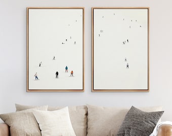 May include: Two framed prints of minimalist illustrations of people skiing and snowboarding on a white background. The prints are hanging on a white wall above a brown couch with white and gray throw pillows.
