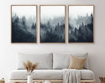 May include: Three framed wall art pieces depict a misty forest scene. The artwork features dark green trees shrouded in fog, creating a moody and atmospheric landscape. The frames are a light brown color, complementing the neutral tones of the room.