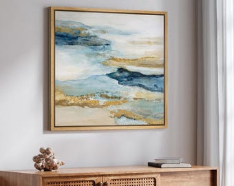 Puede incluir: Una pieza de arte mural cuadrada que presenta una pintura de paisaje abstracto con bandas horizontales superpuestas de azul marino, azul claro, crema y pintura dorada metálica. La obra está enmarcada en un marco de madera fina.