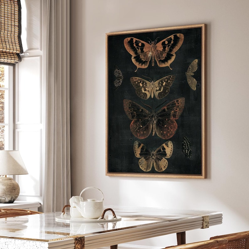 May include: A framed print of a dark background with five butterflies in various shades of brown, orange, and yellow. The butterflies are arranged vertically, with the largest butterfly at the top and the smallest butterfly at the bottom.
