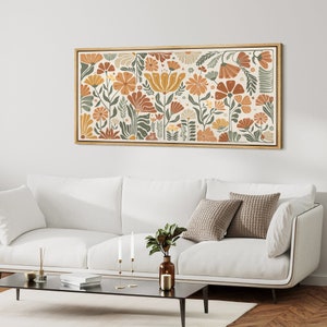 May include: A framed print of a floral design with orange, yellow, and green flowers on a cream background.