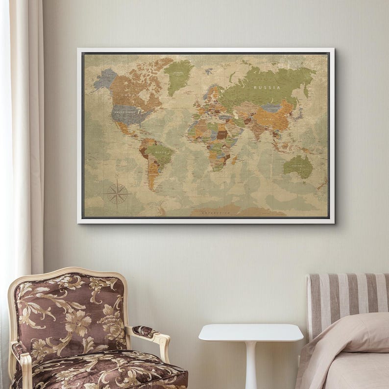 Puede incluir: Un mapa del mundo enmarcado con una est&eacute;tica vintage. El mapa presenta una paleta de colores neutros con tonos beige, marr&oacute;n y verde, y est&aacute; montado en un marco blanco. El mapa incluye nombres de pa&iacute;ses y una rosa de los vientos.