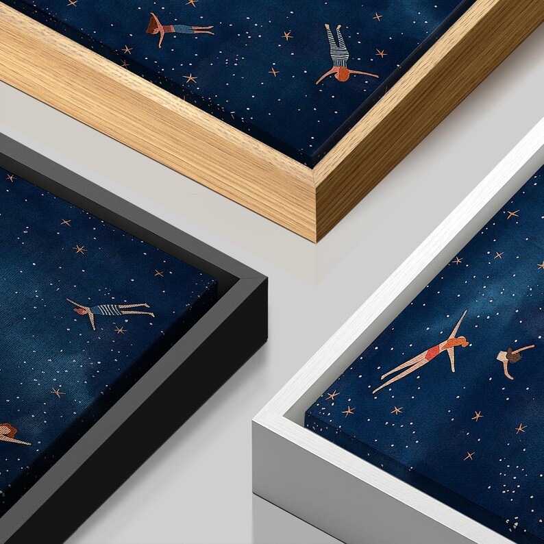 Op de afbeelding: Een ingelijste print van een blauwe sterrenhemel met figuren in badpakken die in de lucht zweven. De lijst is verkrijgbaar in zwart, wit en hout.