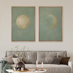 May include: Two framed rectangular wall art prints featuring a sage green background with a textured finish. The left print displays a full moon, while the right print shows a crescent moon. Both images include a swarm of small black birds.