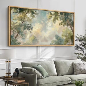 May include: A large rectangular canvas art piece with a wooden frame. The artwork depicts a serene forest scene with a soft, painterly style. The color palette includes greens, blues, and yellows, creating a calming atmosphere. The image is of a forest canopy.