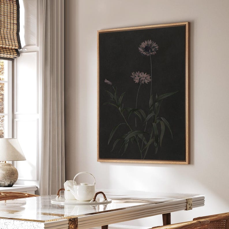 Puede incluir: Una impresi&oacute;n bot&aacute;nica enmarcada con un fondo oscuro, que presenta una ilustraci&oacute;n detallada de flores y follaje. La obra de arte se presenta en un marco de madera. Las flores son de un suave color p&uacute;rpura, a&ntilde;adiendo elegancia.