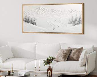 Puede incluir: Una obra de arte enmarcada que representa un paisaje montañoso nevado con esquiadores. La obra presenta un diseño texturizado en blanco sobre blanco con sutiles acentos grises para los árboles y los esquiadores. El marco es de color madera natural.