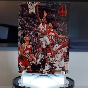 May include: A basketball trading card featuring a player in a red jersey with the number 44, jumping to make a basket. The card is from the 4 Sport series.