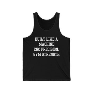 May include: Black tank top with white text that reads "BUILT LIKE A MACHINE CNC PRECISION, GYM STRENGTH".