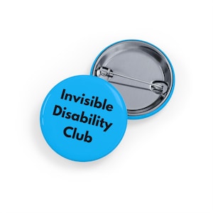 May include: A round pinback button with a bright blue background and the black text "Invisible Disability Club" printed on the front. The back of the button is metallic silver and features a horizontal pin mechanism for attachment to clothing.