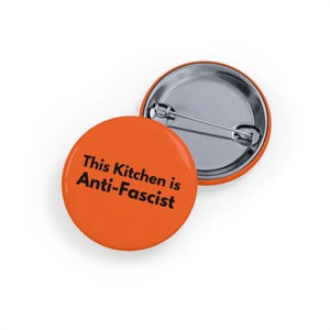 Diese Küche ist antifaschistisch (Anstecknadel, 4 Größen) Gemeinschaftsmahlzeiten, Ernährungsgerechtigkeit & Solidarität, Ernährungsunsicherheit - Orange
