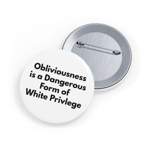 May include: Two white round buttons with a safety pin backing. One button displays the text "Obliviousness is a Dangerous Form of White Privilege" in black font. The other button is silver.