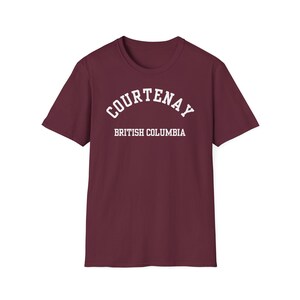 Peut inclure: T-shirt bordeaux avec le mot "COURTENAY" en blanc en arc de cercle au-dessus de "BRITISH COLUMBIA" en lettres blanches. Le t-shirt a des manches courtes et un col rond, idéal pour un look décontracté.