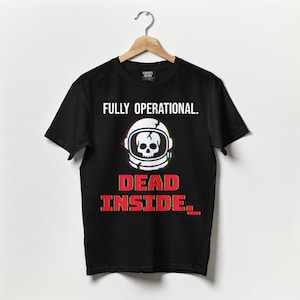 May include: Black t-shirt featuring the text "FULLY OPERATIONAL." above a graphic of an astronaut helmet with a skull. Below the helmet, the text "DEAD INSIDE." is displayed in red.
