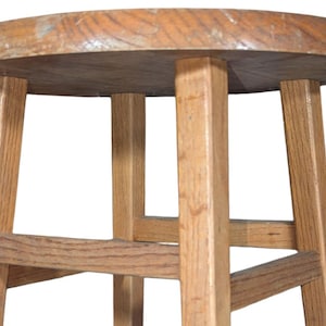 以下が含まれることがあります： 丸い座面と4本の脚を持つ木製のスツール。シンプルなデザインで、天然木で作られています。