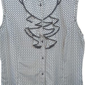 May include: Sleeveless blouse with a black and white geometric pattern. The blouse features a ruffled accent down the front and a dark trim along the neckline and armholes. The brand name "Tahari" is visible on the label.