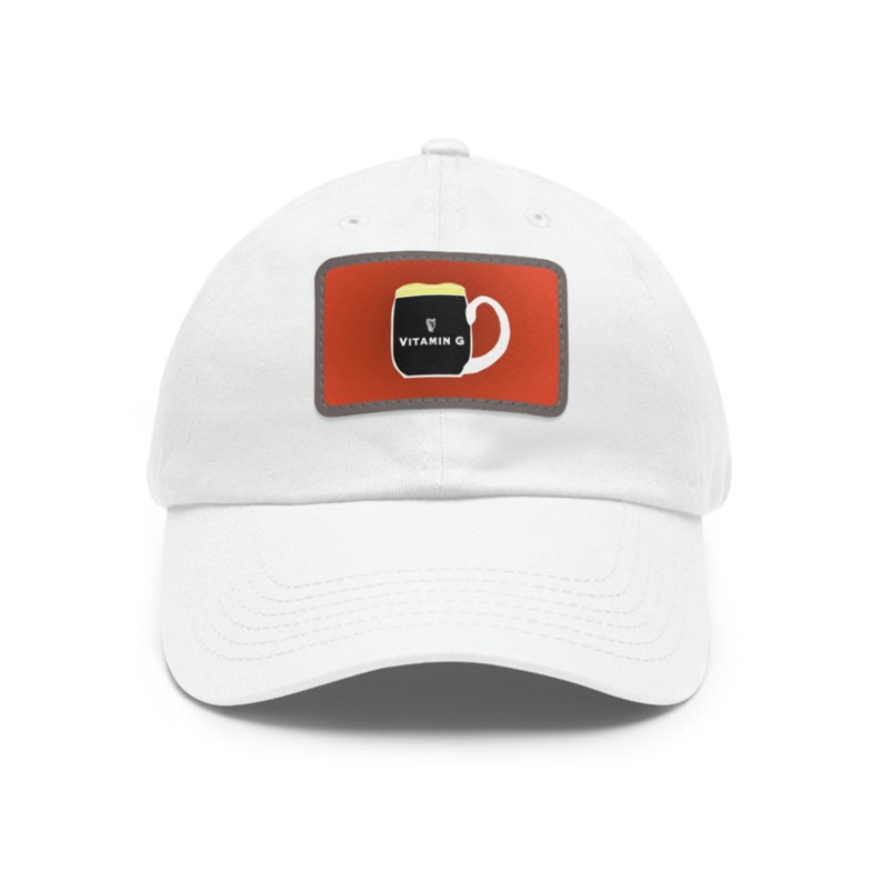May include: White baseball cap with a red patch featuring a black mug with a yellow foam top and the text "Vitamin G".