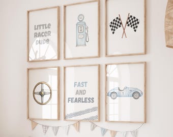 May include: A set of six framed art prints with a racing theme. The prints feature illustrations of a gas pump, checkered flags, a steering wheel, a vintage race car, and text that reads "Little Racer Dude" and "Fast and Fearless".