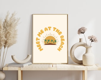 May include: A yellow and white print with the text "Meet me at the beach" in a curved arc. The text is in a retro font. A yellow sun with orange rays and green palm trees is in the center of the arc.