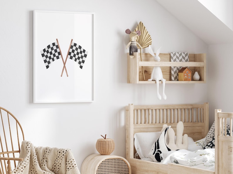 May include: A framed print featuring two crossed checkered racing flags in black and white. The flags are set against a white background, creating a minimalist design. The artwork is displayed in a bright, airy room, suggesting a children's bedroom theme.