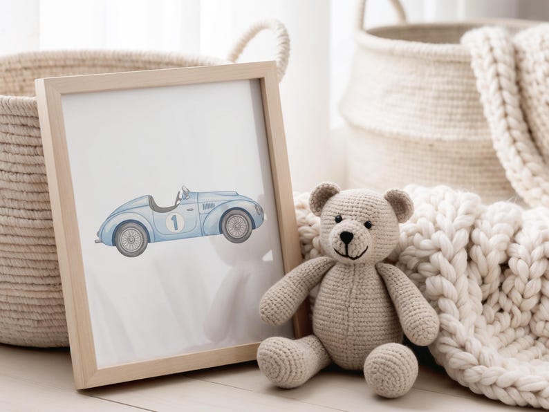 May include: A framed print featuring a light blue vintage race car with the number 1. A beige crocheted teddy bear sits next to the frame. Woven baskets and a cream-colored blanket are in the background.