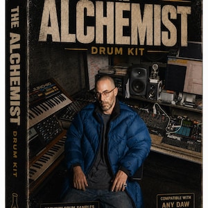 May include: A product box for "The Alchemist Drum Kit" featuring a man in a blue puffer jacket. The box has text that reads "Premium Drum Samples", "24-Bit WAV", and "100% Royalty Free". The box is compatible with any DAW.