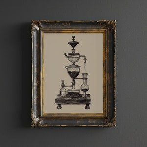 Pode incluir: Uma ilustração em preto e branco emoldurada de uma cafeteira vintage com uma jarra de vidro e vários tubos. A cafeteira está em uma moldura dourada com um acabamento desgastado.