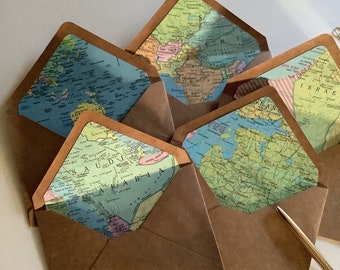 May include: Five brown paper envelopes with different vintage world maps inside. The maps are in various colors and show different continents and countries.