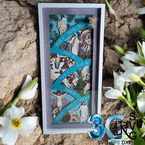 May include: A framed, layered paper art piece depicting scenes from Holy Week. The artwork features teal ribbons with the days of the week, and illustrations of biblical events. The frame is white, and the background is a stone texture.