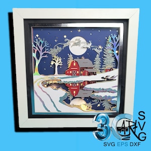May include: A framed paper art piece depicting a winter scene with a red barn, snow-covered landscape, and Santa's sleigh. The artwork features a white frame, a black inner border, and a blue night sky with a full moon and stars. The image includes the text "SVG EPS DXF".