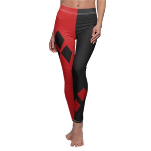 Puede incluir: Leggings con un diseño dividido, con una combinación de colores rojo y negro. El lado rojo tiene formas de diamante negras. Los leggings son ajustados y están hechos de una tela suave. La cintura es blanca.