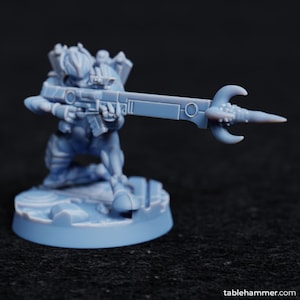 Könnte beinhalten: Eine hellblaue Plastikminiatur einer knienden Figur, die ein futuristisches Gewehr mit einer gebogenen Klinge am Ende hält. Die Figur steht auf einem runden Sockel.