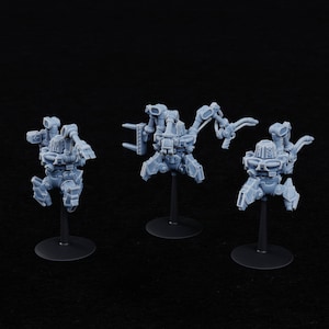 May include: Three gray plastic miniature robots with articulated limbs and various weapons. The robots are posed on black bases.