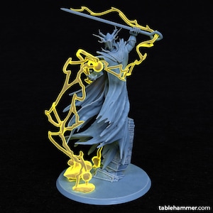 May include: A gray 3D printed miniature of a figure wielding a sword and surrounded by yellow lightning. The figure is wearing a cloak and a helmet with horns. The miniature is standing on a circular base.