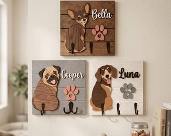 May include: Three square wooden wall-mounted organizers featuring layered dog cutouts and names. The top board is dark brown with a chihuahua named Bella. The bottom left is gray with a pug named Cooper. The bottom right is white with a dachshund named Luna.