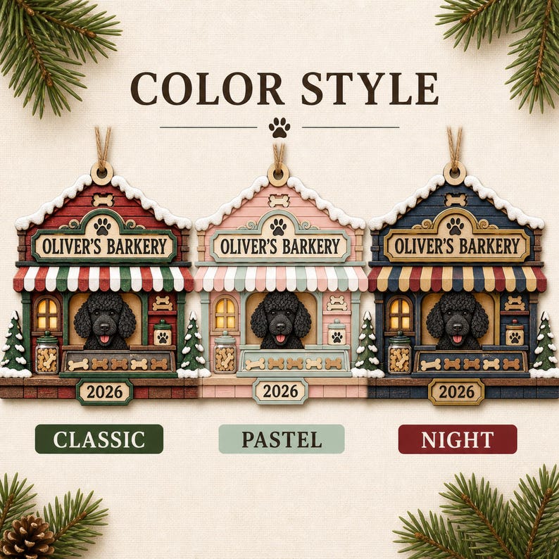 May include: Three house-shaped ornaments labeled OLIVER'S BARKERY and 2026, featuring a black poodle in a shop window. The versions are Classic in red and green, Pastel in pink and light blue, and Night in dark blue and red, all with hanging twine.