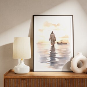 May include: A watercolor painting of a person walking away from the viewer on a beach with a small boat in the distance. The painting is framed in a black frame and is hanging on a wall.