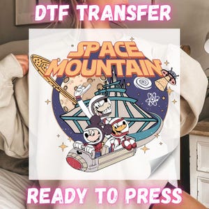 May include: White t-shirt featuring a colorful graphic of Mickey Mouse, Goofy, and Donald Duck in space suits on a Space Mountain ride. The words "SPACE MOUNTAIN" are in orange and white. The text "DTF TRANSFER" and "READY TO PRESS" are also visible.